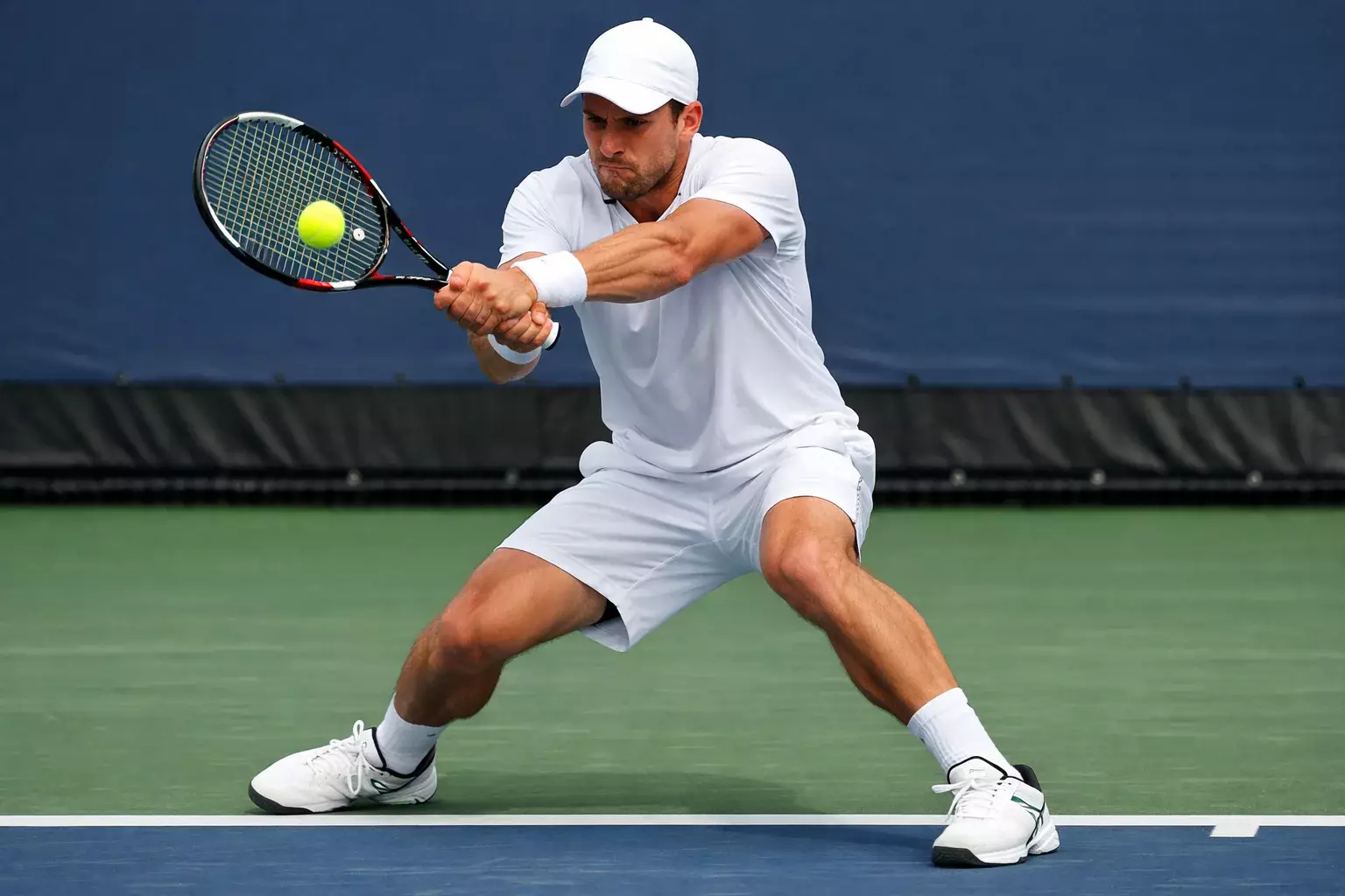 Tenista devolviendo un golpe potente desde el fondo de pista