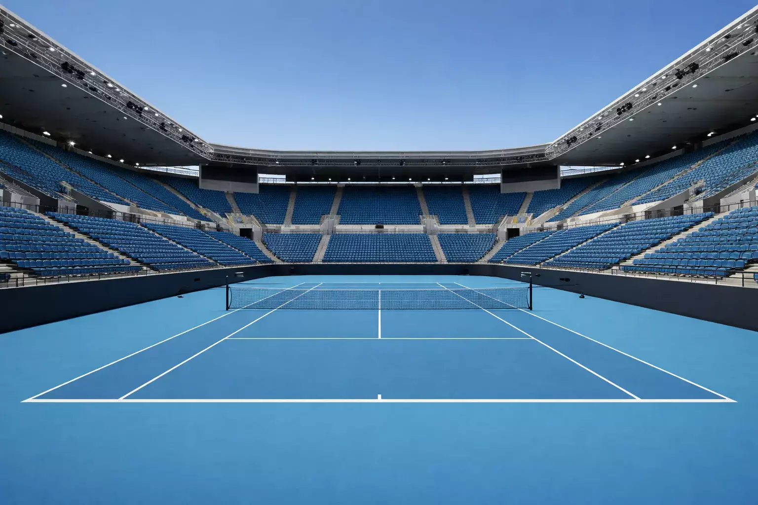 Estadio de tenis con pista dura azul bajo cielo despejado